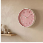 Pink clock styled in a warm home setting
