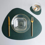 Modern green leather placemat and coaster set with gold cutlery.