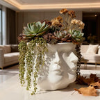 White ceramic planter shaped like a face with succulents and dried flowers in a living room setting.