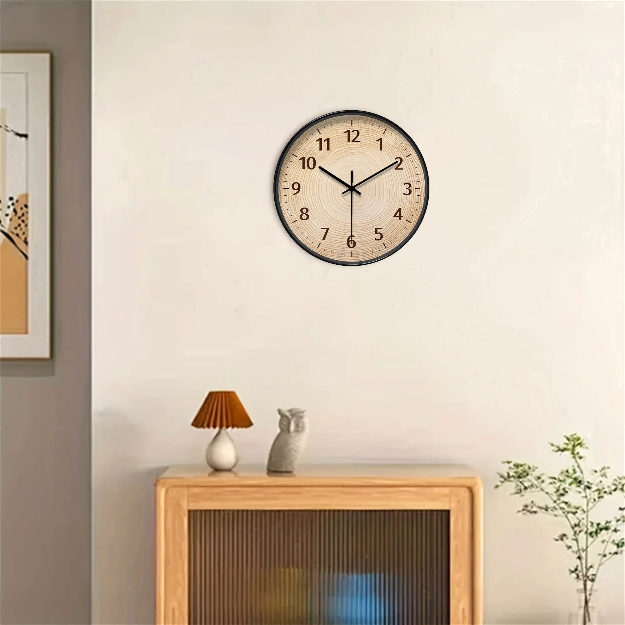 Round, wood-grain wall clock with black frame and Arabic numerals.