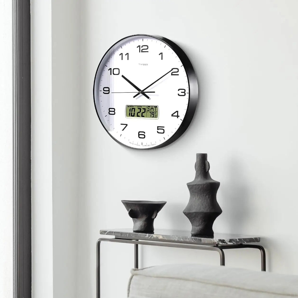 Black metal wall clock with a digital calendar display.