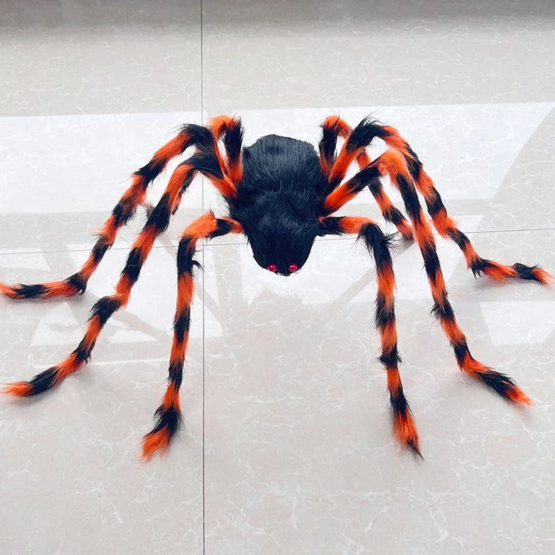 A large Halloween toy spider with a black body and bright orange and black striped legs, positioned on a light gray tiled floor.
