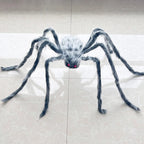 A large fake spider decoration with long hairy legs and red eyes, placed on a light beige tiled floor.
