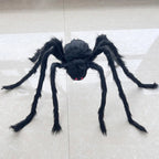 A large black hairy spider toy with red eyes, displayed on a light beige tiled floor.