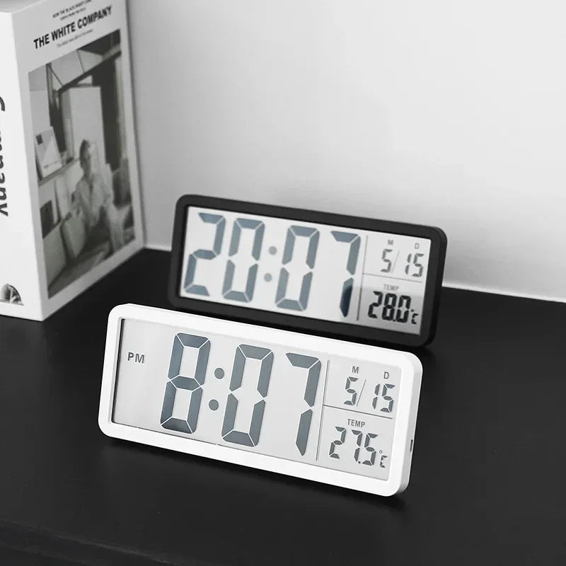Two digital clocks displaying time and temperature on a dark surface with a white background.