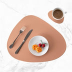 Brown leather placemat and coaster set with a modern, organic shape.