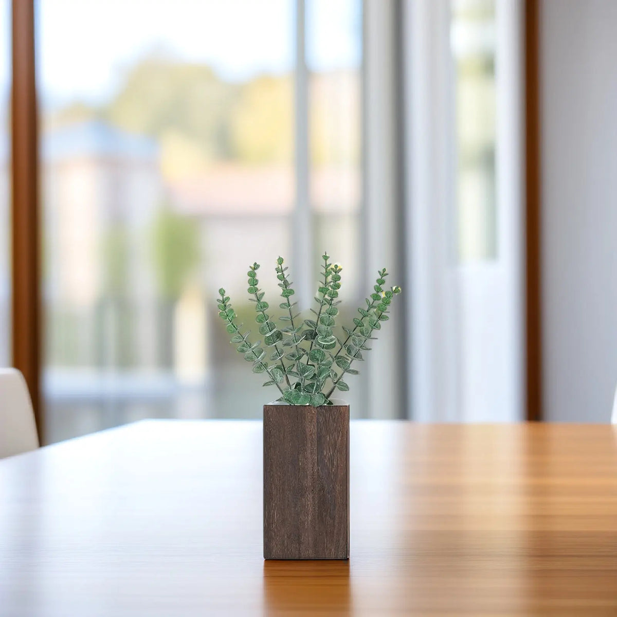 A dark brown rectangular wood planter holds a green faux plant with round leaves, sitting on a glossy wooden table.